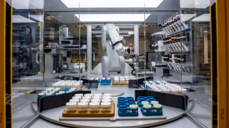 A robot is working in a factory with a lot of bottles.
