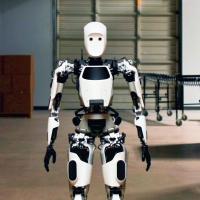 A white and black robot standing in a warehouse.