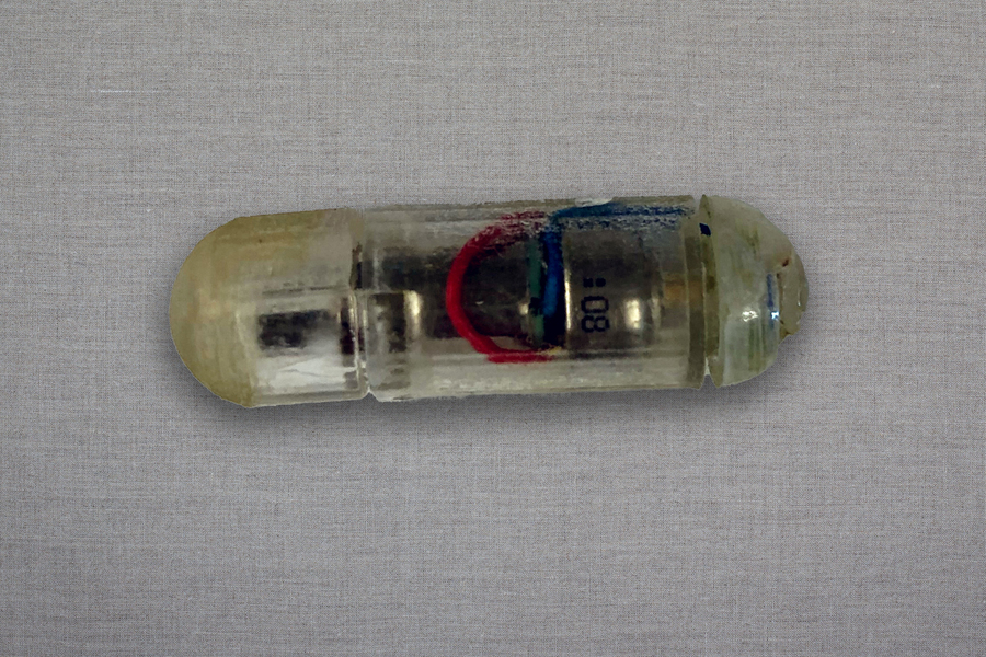 A small plastic bottle with a red and blue label on it.