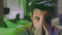 A man experiencing anxiety while covering his face with his hands.