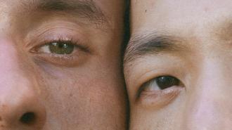 A close up of two men looking at each other.