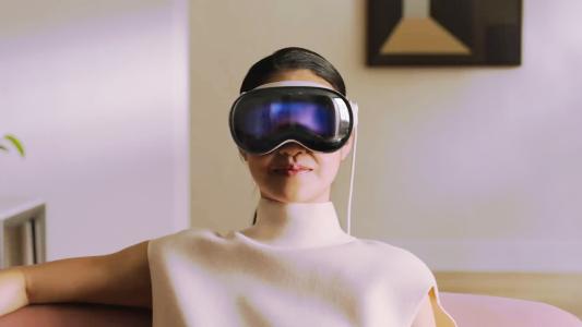 A woman wearing a VR headset sitting on a couch.