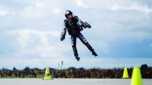 A man using a jet suit to fly above the ground