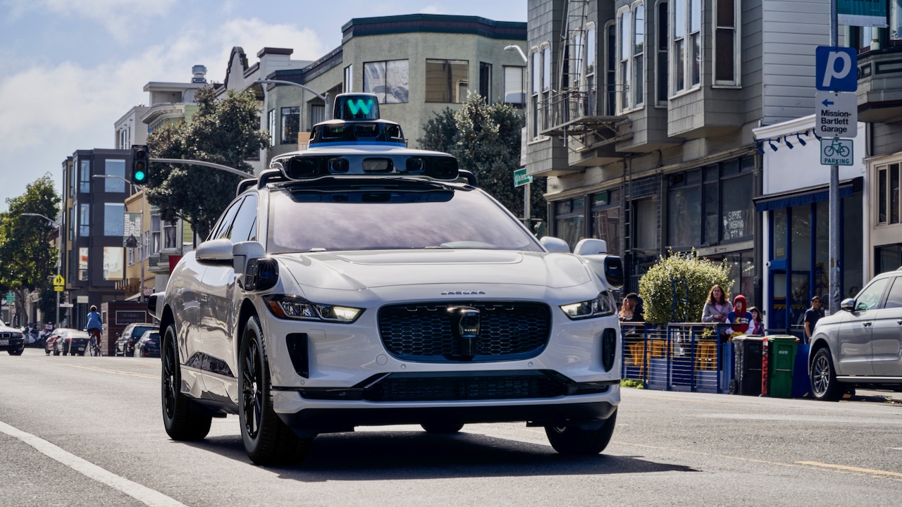 A Waymo vehicle driving down the road