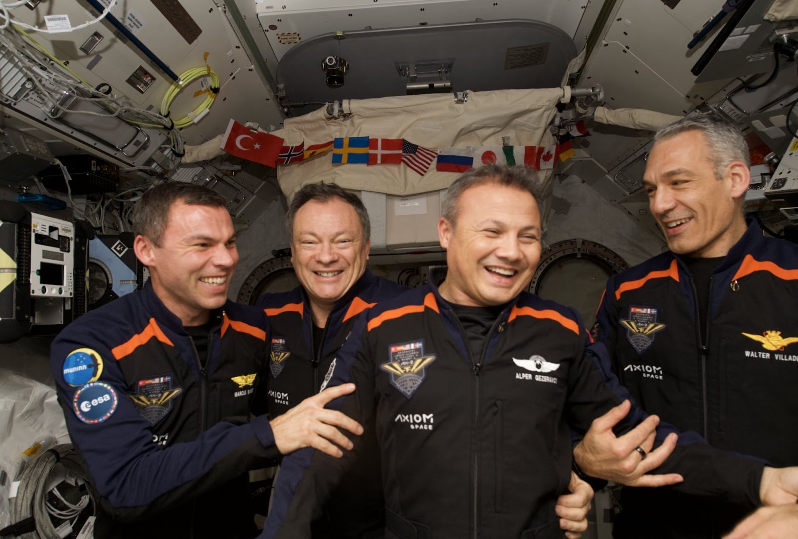 A group of four astronauts in a space station.