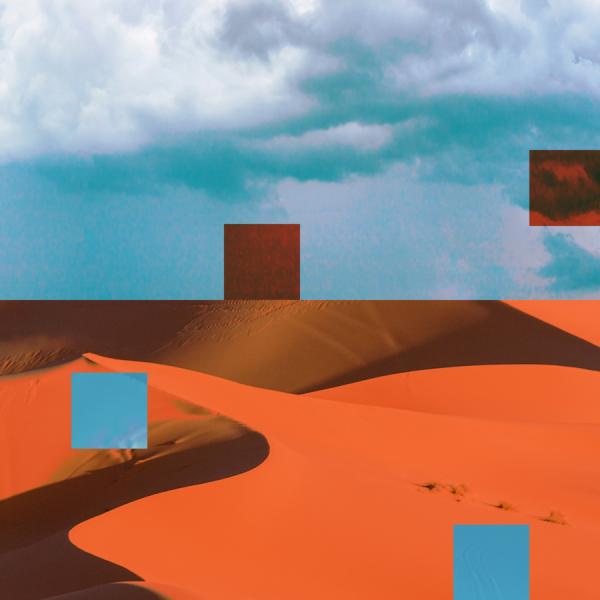 A vibrant red sand dune in the desert with a blue sky