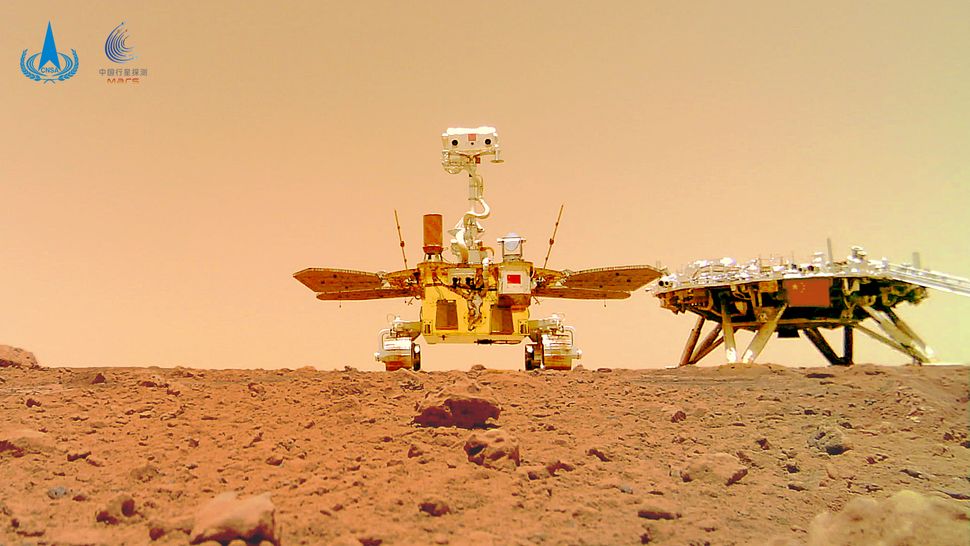 An image of a rover and lander the surface of Mars