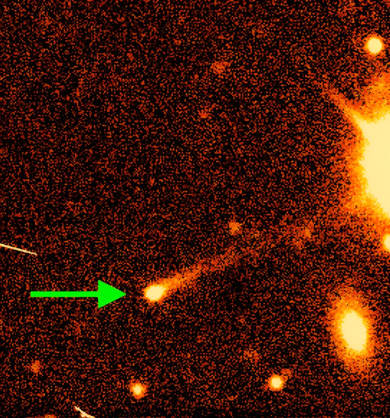 an image of space, with a green arrow pointing to an active asteroid