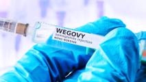 A close up of a Wegovy vial in a gloved hand