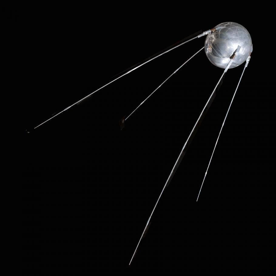 a silver sphere with four thin rods extending from it in the same direction