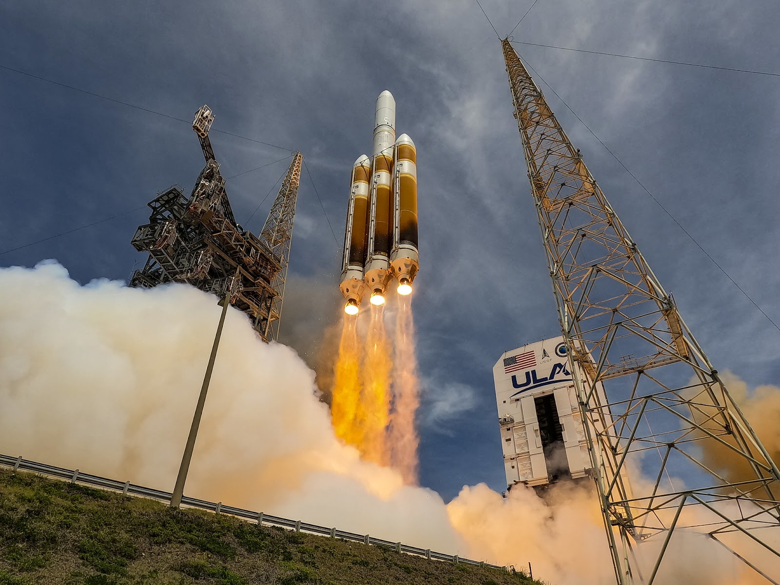 A rocket launching from a ground platform, emitting bright flames and clouds of smoke