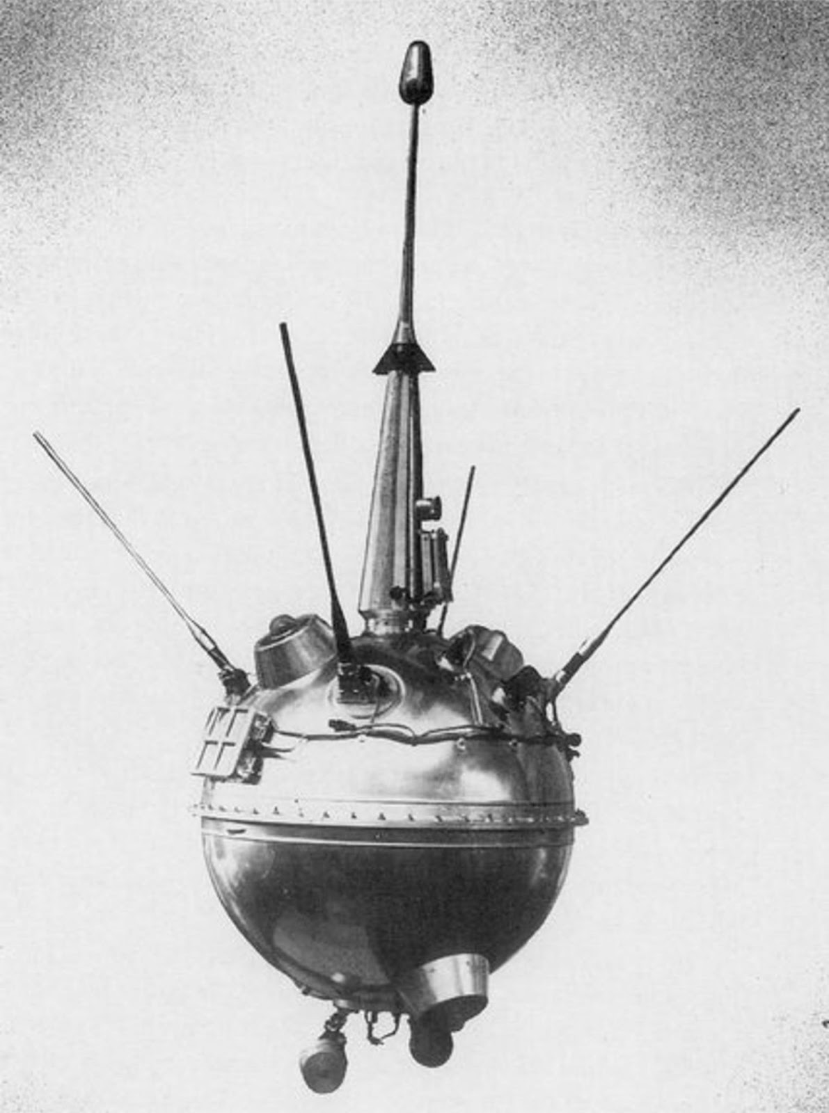 Black and white photo a sphere-like spacecraft with several rods sticking out of it