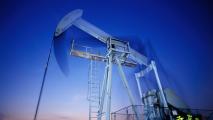 Oil pumpjack operating in the oil fields under a twilight sky.