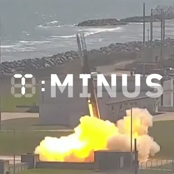 A rocket launch adjacent to a coastal area, emitting a large plume of smoke and flames, with a watermark saying "T-Minus" in the image center.