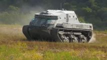 A futuristic armored tank with caterpillar tracks navigating through a grassy field