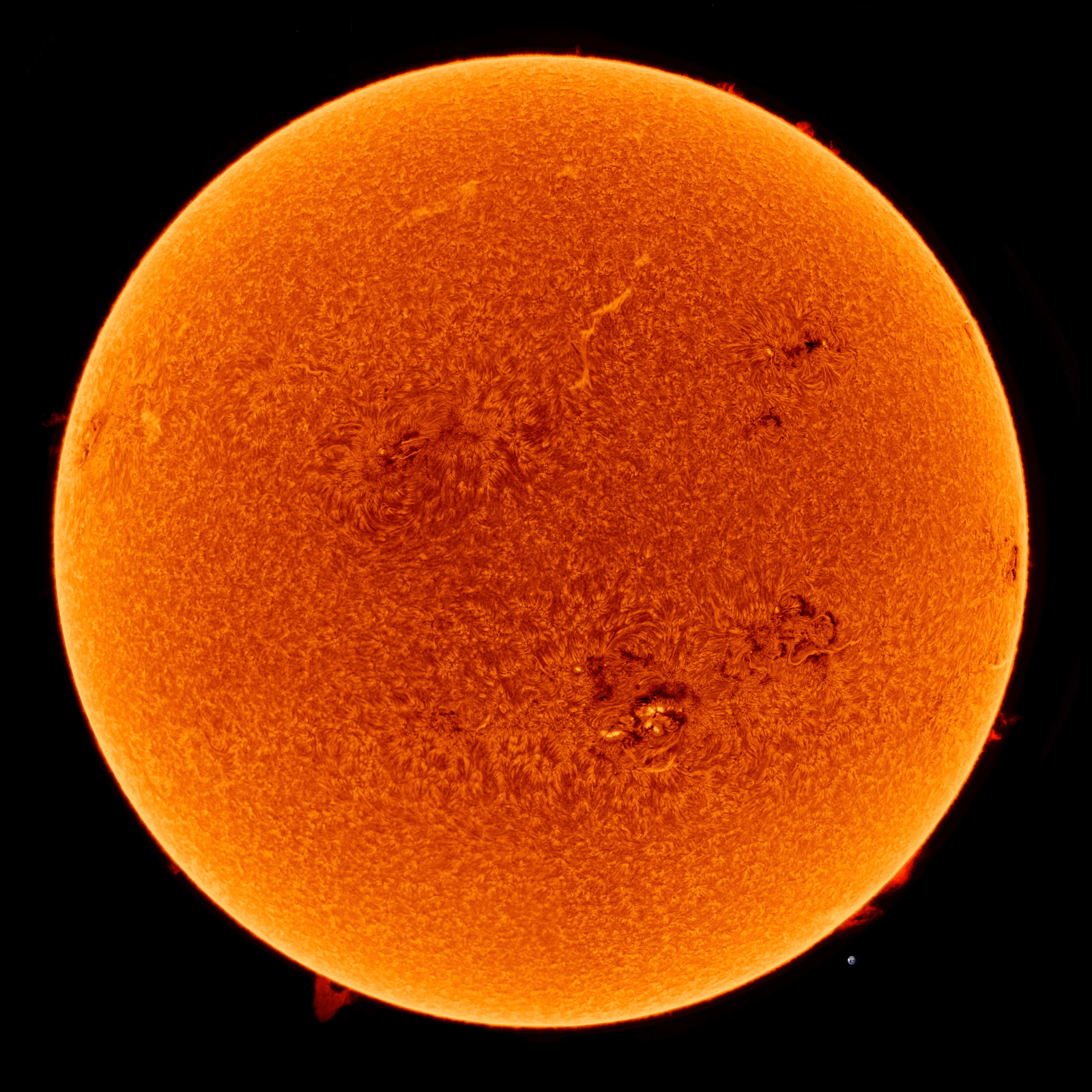 A detailed high-resolution image of the Sun, displaying its turbulent surface with visible sunspots and solar flares, against a black background.