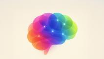 Abstract illustration of a human brain composed of overlapping translucent shapes in vibrant rainbow colors with glowing points.