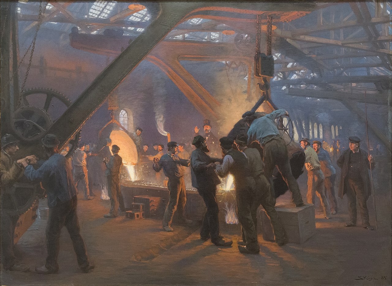Workers operate machinery and pour molten metal inside a large, busy industrial foundry with glowing light from furnaces and mechanical beams overhead.